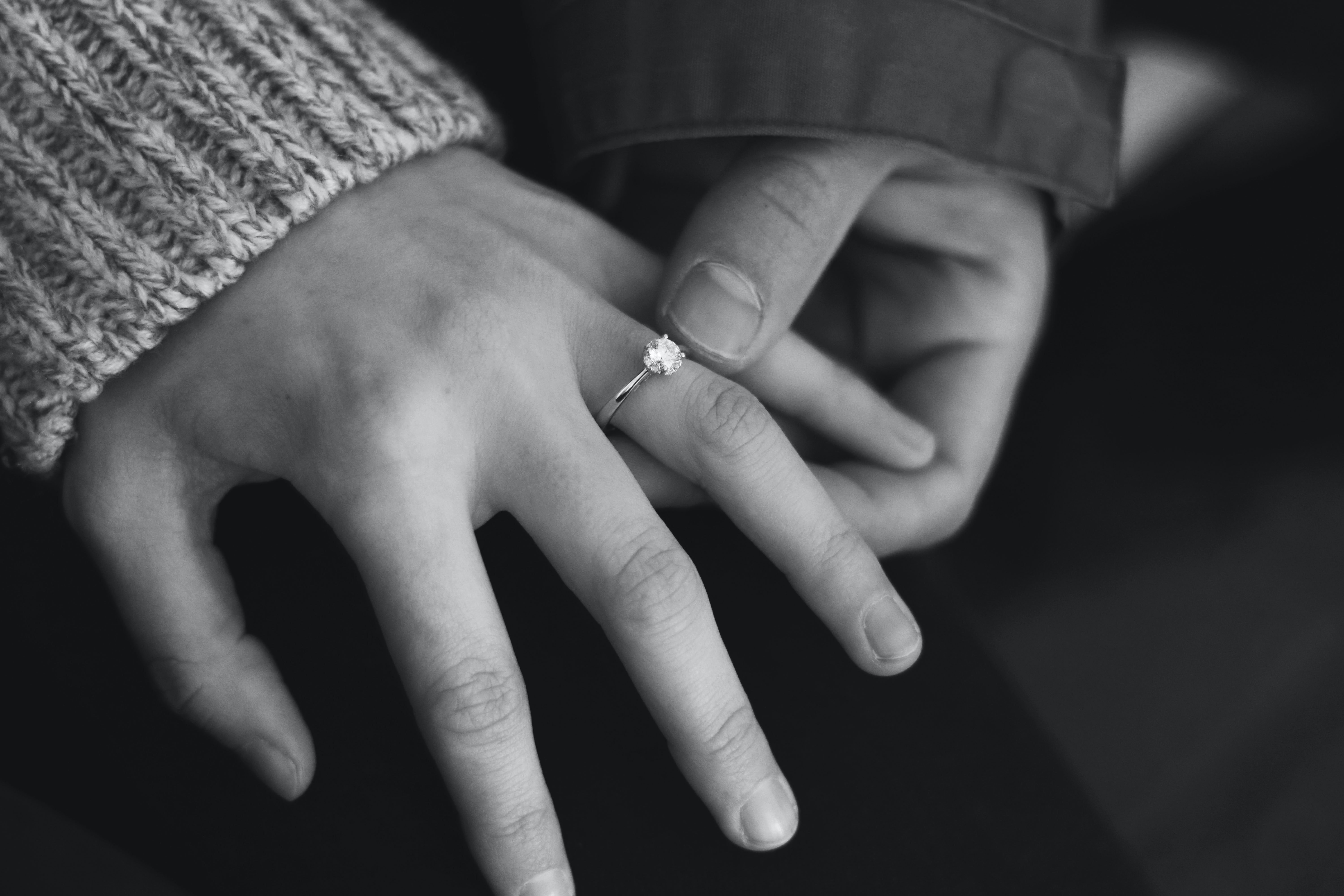 a female hand with an engagement ring is held by another hand